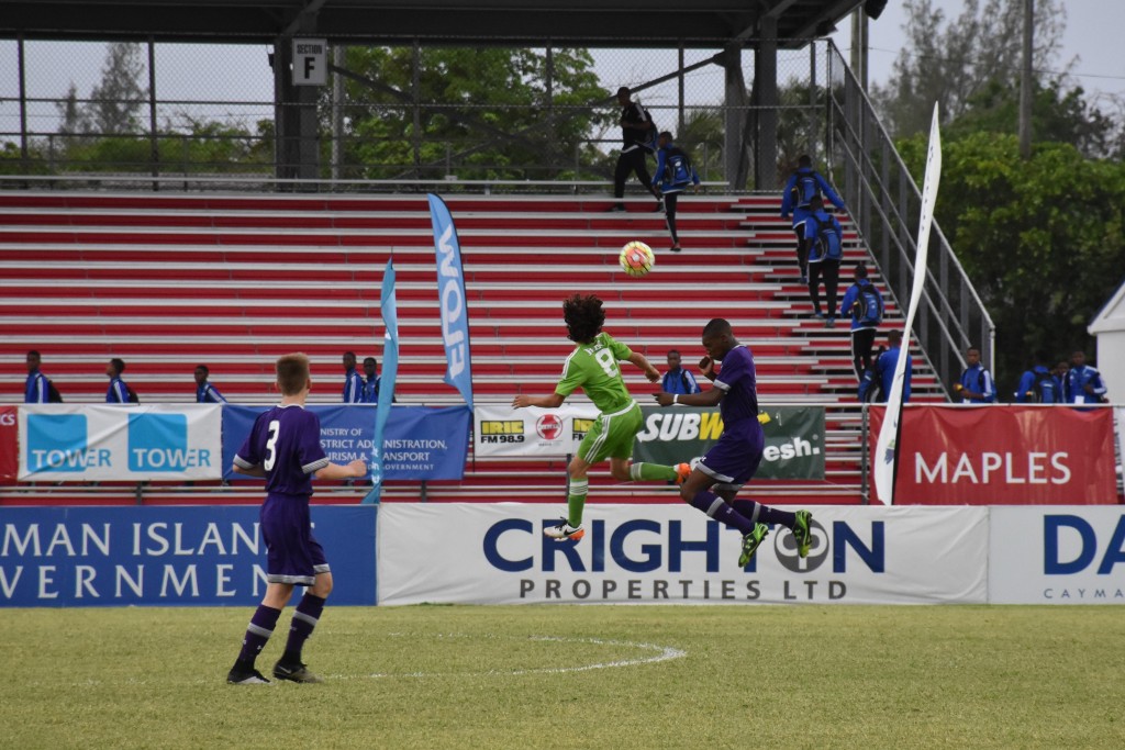 REV's Ben Lessert (#8 green) rises up to head the ball against Tottenham.