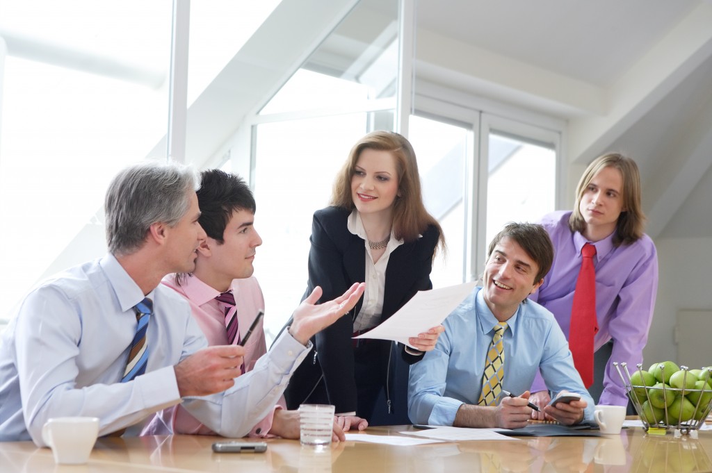 five businesspeople are discussing something on a meeting